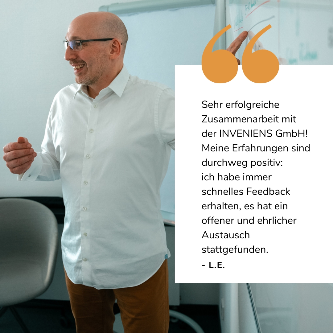 Joachim Trenz zeigt lächelnd auf ein Whiteboard, darunter sieht man eine Google Bewertung